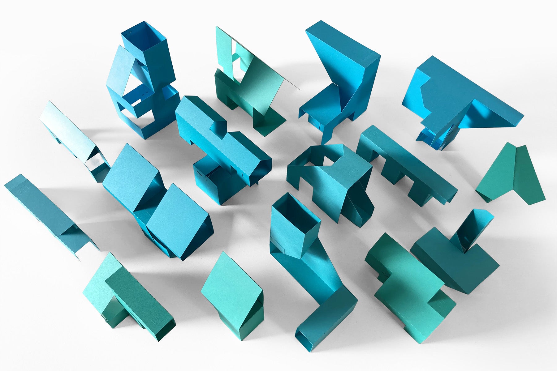 Set of blue geometric paper sculptures on a white background