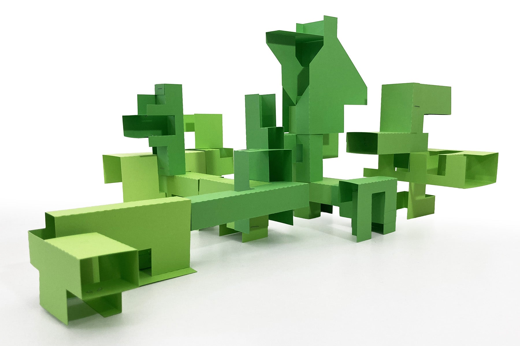 Green geometric modular paper sculpture on a white background