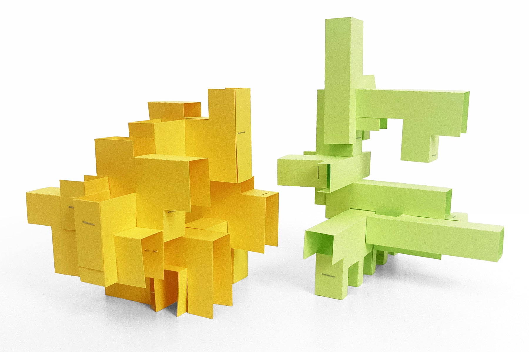 Yellow and green modular paper constructions on a white background