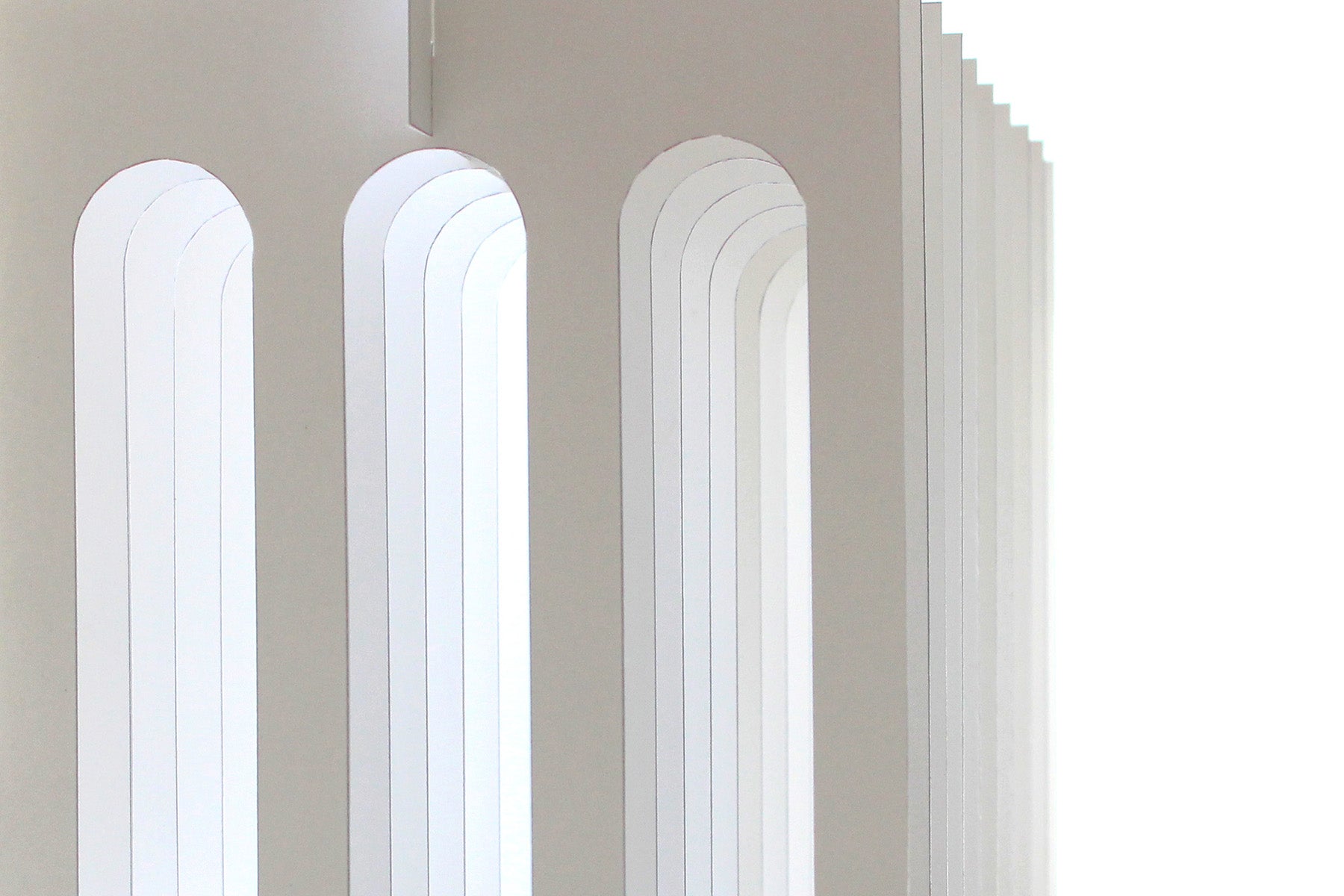 layered white paper arches on white background