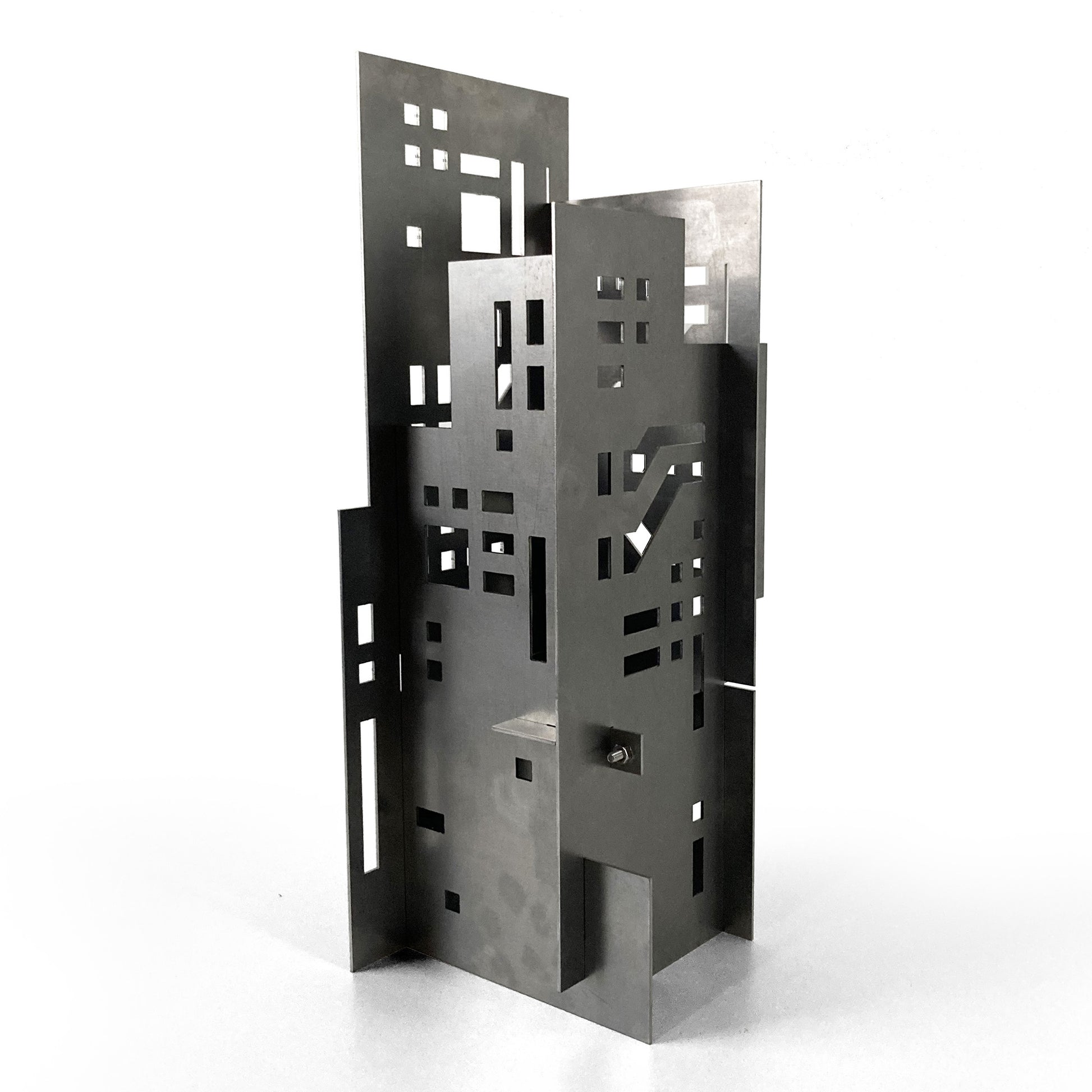 Metallic architectural sculpture with geometric design on a white background