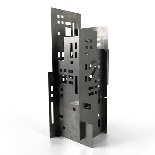 Metallic architectural sculpture with geometric design on a white background