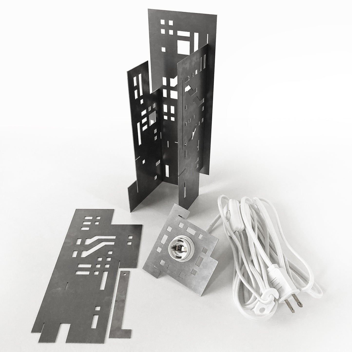 Metallic lamp parts including a base, cover, and power cord on a white background