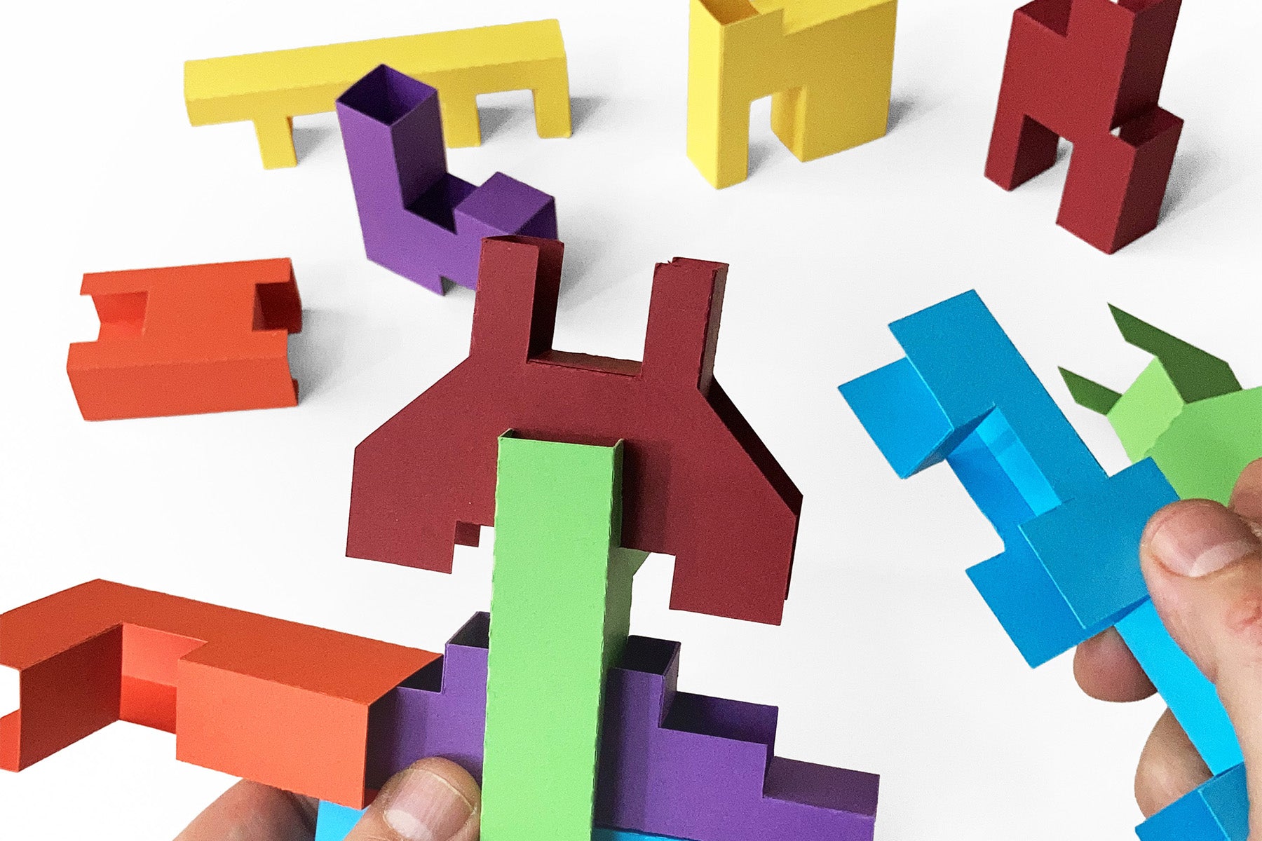 Colorful geometric paper building blocks on a white background