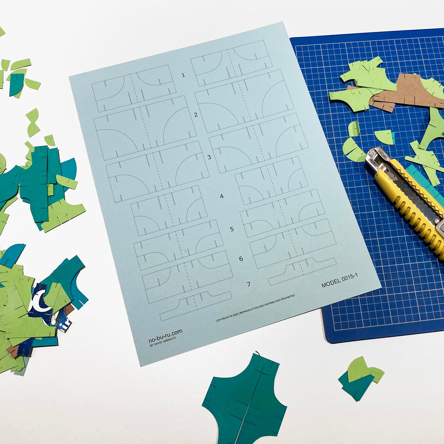 Template sheet with cut-out shapes on a cutting mat with scissors