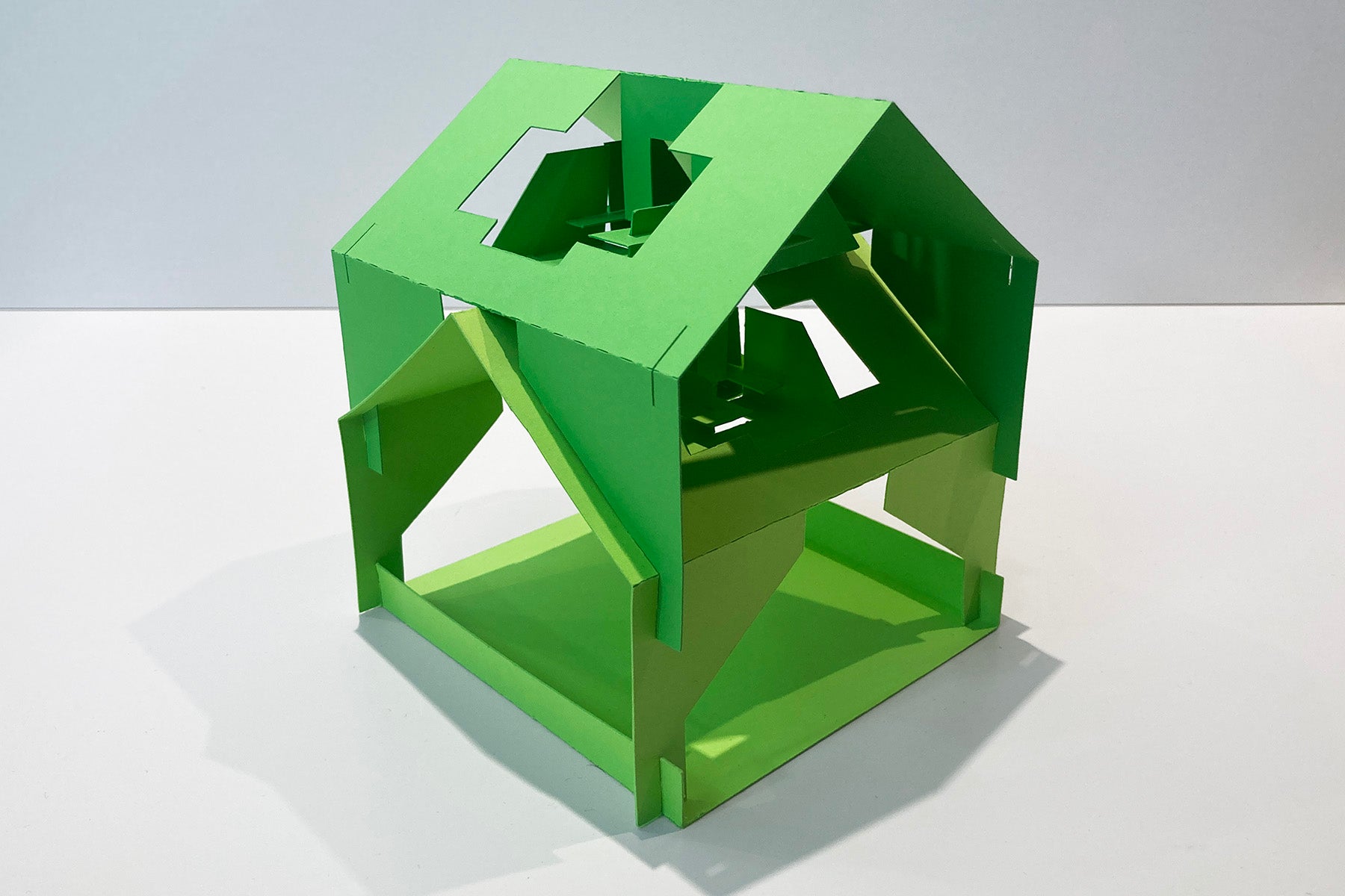 Green geometric 3D puzzle on a white background