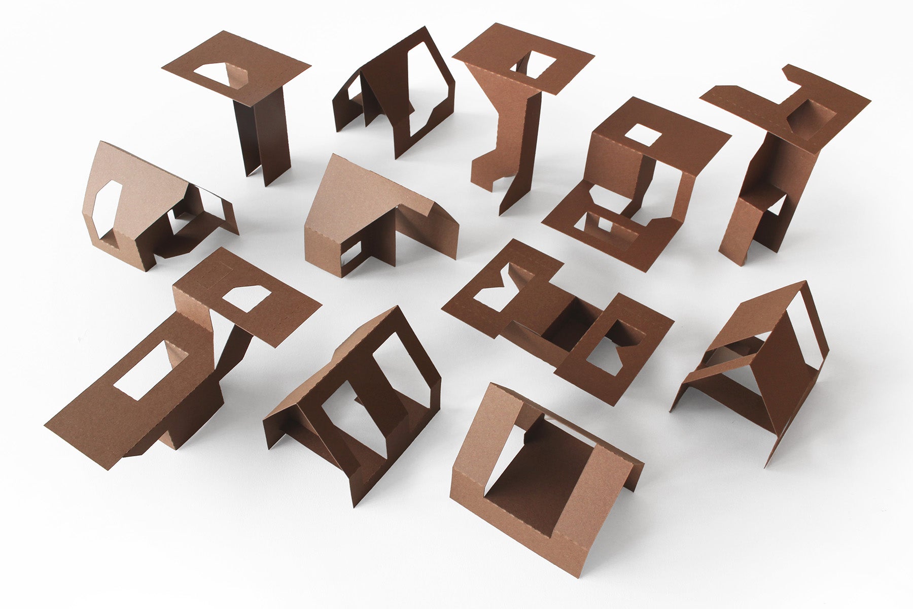 Cardstock cutouts of paper houses on a white surface