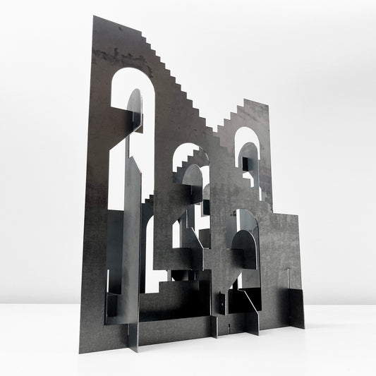 Black geometric sculpture on a white background